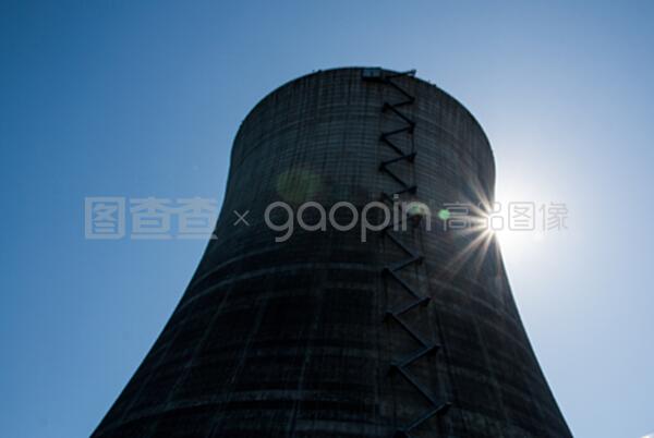 在蓝色天空下的核冷却塔有太阳的爆发